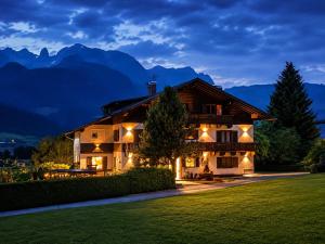 a house at night with mountains in the background at Pension Sonneck in Pfarrwerfen