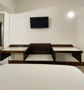 a room with a couch and a tv on a wall at Delphin Beach Hotel in Guarujá