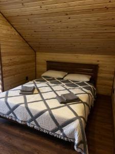 a bedroom with a bed in a wooden room at Foresthillсоttage in Tyshovnitsa