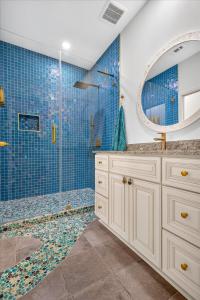 a bathroom with a shower with blue tiles at Ninas Villas - Brand New Luxury Villas in Galveston +72 photos