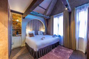 ein Schlafzimmer mit einem großen Bett und einem großen Fenster in der Unterkunft Hotel Cour Saint Georges by CW Hotel Collection in Gent
