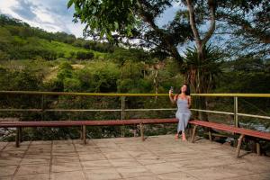 a woman sitting on a bench taking a picture at Hotel para descanso con piscina in San Gil