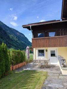 a house with a patio and a table and an umbrella at Haus am Wörtherberg in Rauris