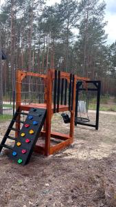 a playground with a slide in a park at Roztoczańska Stodoła in Majdan Sopocki