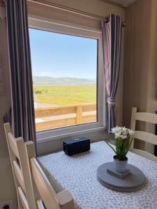 a table with a vase of flowers and a window at Beachcomber's Paradise in Castlegregory