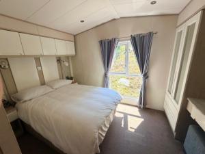 a bedroom with a large bed and a window at Beachcomber's Paradise in Castlegregory