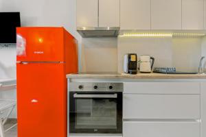 a kitchen with an orange refrigerator and a stove at InTown Suite in Lefkada