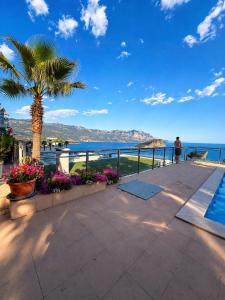 a man standing on a balcony looking at the ocean at Vista Mare Vidikovac in Budva