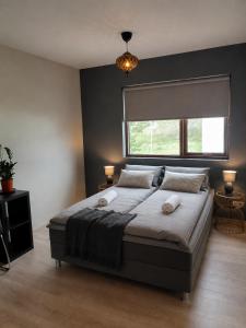 a bedroom with a large bed and a window at Elliðaár Valley Guesthouse in Reykjavík