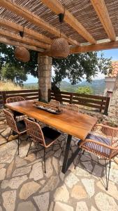a wooden table and chairs on a patio at Koukoutsa House with Swimming Pool Corfu Sokraki in Sokrákion