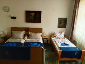 a bedroom with two beds and a clock on the wall at Gasthaus & Pension Schmidt's in Haldensleben