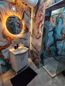 a bathroom with a sink and a painting on the wall at Studio 714 in Škaljari +3 photos