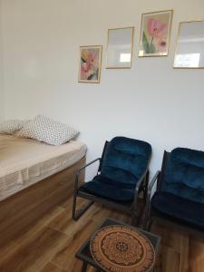 a room with two chairs and a bed and a table at Studio 714 in Škaljari