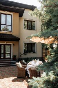 a patio with a table and chairs in front of a house at Otte in Myrhorod