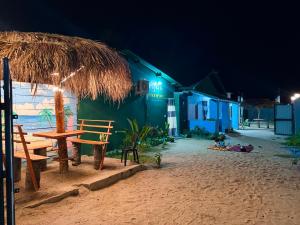 a table and chairs on the beach at night at Afaa Beach Guest House in Arugam Bay