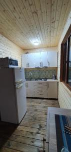 a kitchen with white appliances and a wooden floor at Midamo in Manglisi