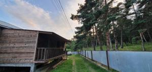 a wooden building next to a fence and a car at Midamo in Manglisi