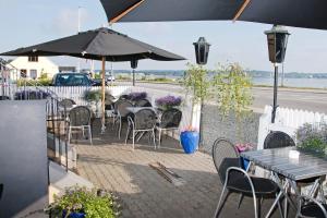 an outdoor patio with tables and chairs and an umbrella at Sølyst Kro- Restaurant og Hotel I/S in Aabenraa