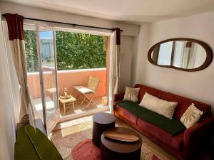 a living room with a couch and a large window at L'Amour des Îles - Centre - Plage - Parking in Cabourg