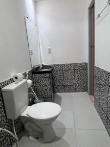 a bathroom with a toilet and a mirror on the wall at Suítes Nativa in Trairi