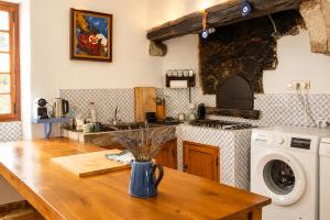 a kitchen with a table with a washing machine at Le Mas de la Vivande in Marsanne