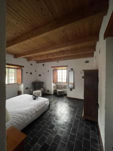 a bedroom with a large bed and a wooden ceiling at Robalinho's House in Faja Grande