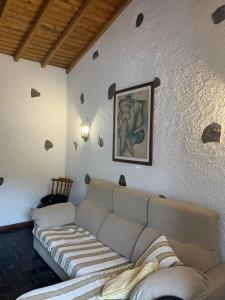 a living room with a couch and a painting on the wall at Robalinho's House in Faja Grande