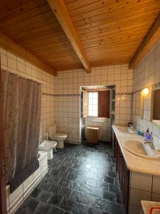 a large bathroom with two sinks and a toilet at Robalinho's House in Faja Grande