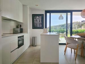 a kitchen with white cabinets and a table with a view at Higuerón Prestige homes in Fuengirola