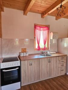 a kitchen with a sink and a stove and a window at Vikendice Una i Andrea in Bileća