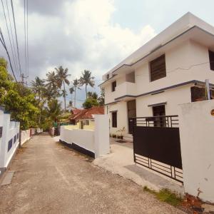 a street in front of a white house at Ebenezer Stay in Trivandrum