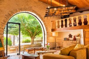 a living room with an archway with a couch and a table at Le Mas de la Vivande in Marsanne