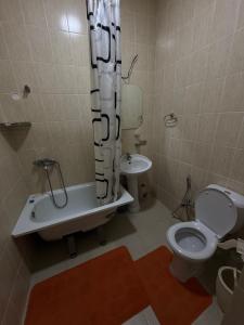 a bathroom with a toilet and a tub and a sink at MdomIK in Chok-Tal +6 photos
