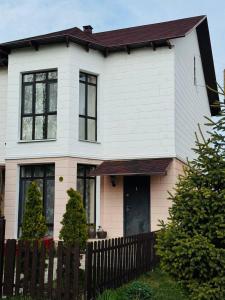 a white and brown house with a wooden fence at MdomIK in Chok-Tal