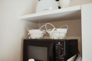 two baskets sitting on top of a microwave at Corte Altobelli Rooms Bitonto in Bitonto