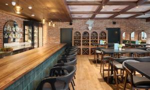 a bar with tables and chairs in a restaurant at Aminess Florian & Godler Hotel in Karlovac