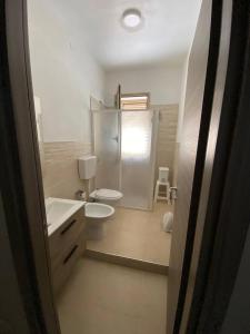 a white bathroom with a toilet and a sink at Trinacria in Montevago