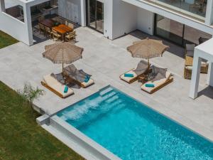 an overhead view of a swimming pool with chairs and umbrellas at Serenita luxury villa in Zakynthos