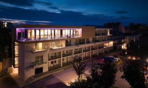 an apartment building with a lit up facade at night at Aminess Florian & Godler Hotel in Karlovac +58 photos