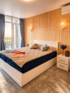 a bedroom with a large bed and a balcony at Trio Villas Retreat in Grigoleti