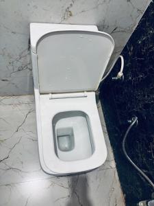 a white toilet sitting in a bathroom stall at Barsana Geust House in Khātu