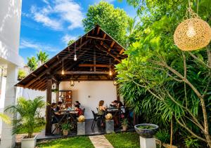 a restaurant with people sitting at tables in a garden at Walawa Valley Rest Inn in Udawalawe