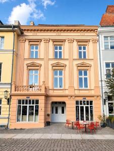 a large building with red tables in front of it at Apartments am Alten Markt in Stralsund