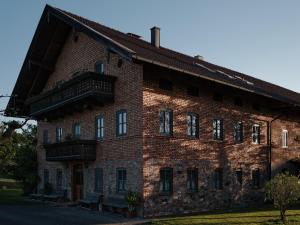 a large brick building with a balcony on it at Gschwingerhof in Riedering