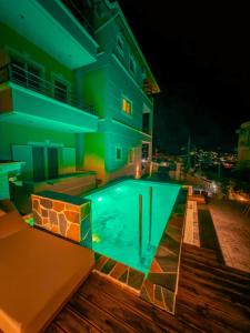 a swimming pool in front of a building at night at Villa Xani in Himare