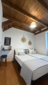 two beds in a room with wooden ceilings at Koukoutsa House with Swimming Pool Corfu Sokraki in Sokrákion +46 photos