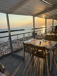 a table and chairs on a balcony with the ocean at Respiro Di Mare in Torre del Greco