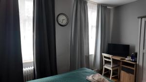 a bedroom with a bed and a clock on the wall at EVIA Hotel restaurant in Recklinghausen