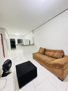 a living room with a brown couch and a black rug at Casa Mobiliada Plus Gurupi in Gurupi