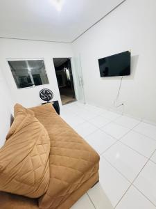 a living room with a couch and a flat screen tv at Casa Mobiliada Plus Gurupi in Gurupi +1 photo